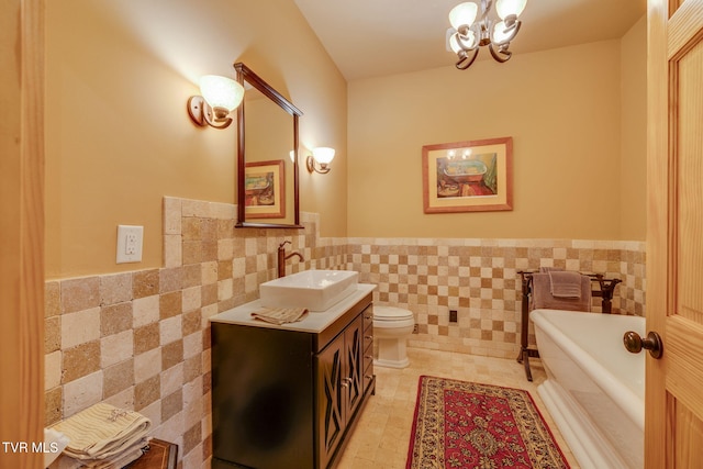 bathroom featuring a freestanding bath, a wainscoted wall, and tile walls
