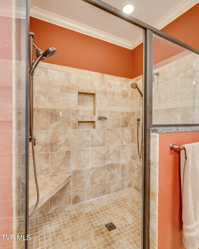 bathroom with ornamental molding and a shower stall