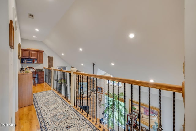 hallway featuring recessed lighting, lofted ceiling, and light wood-style floors