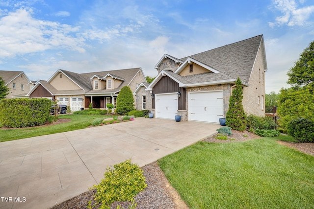 craftsman-style home with driveway, roof with shingles, a front lawn, an attached garage, and stone siding