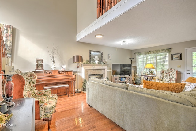 living area with light wood-type flooring and a high end fireplace