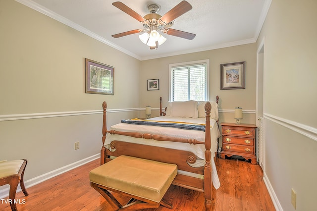 bedroom featuring ornamental molding, a ceiling fan, baseboards, and light wood-type flooring