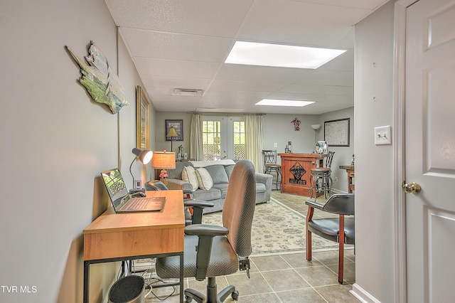 home office featuring light tile patterned flooring, visible vents, and a paneled ceiling