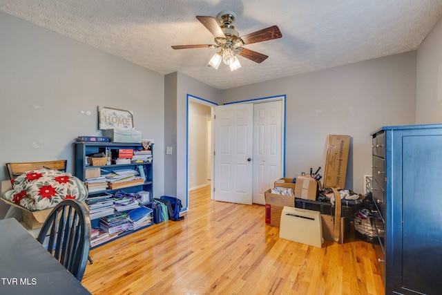 miscellaneous room with wood finished floors, ceiling fan, and a textured ceiling