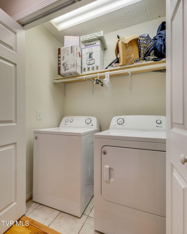laundry room with light tile patterned floors, separate washer and dryer, and laundry area