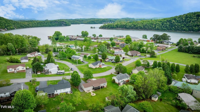 drone / aerial view with a forest view, a water view, and a residential view