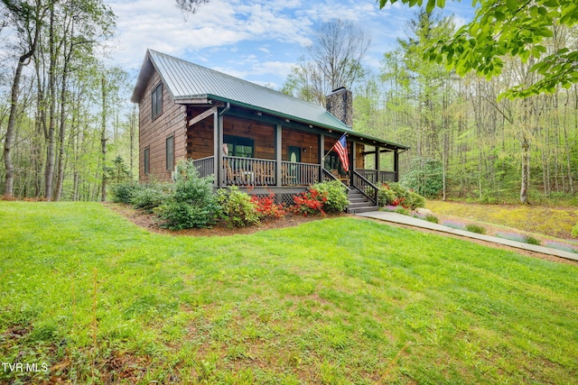view of front of house featuring a chimney, a porch, a front lawn, and metal roof