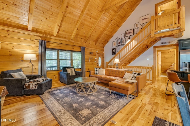 living area with light wood-style flooring, beam ceiling, wooden walls, and high vaulted ceiling