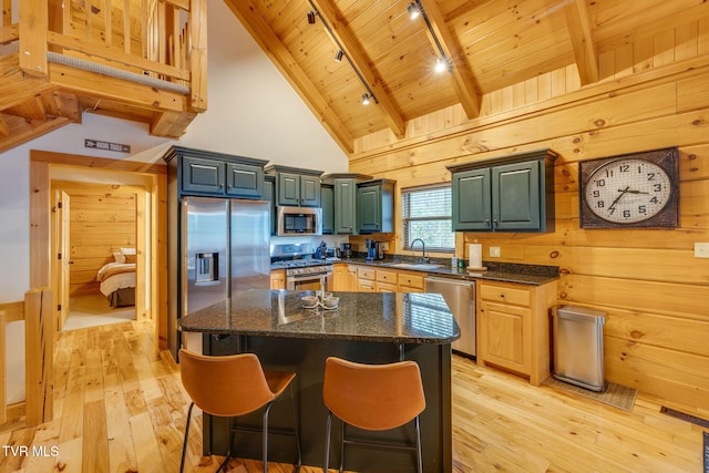 kitchen with a sink, wood ceiling, rail lighting, light wood finished floors, and appliances with stainless steel finishes