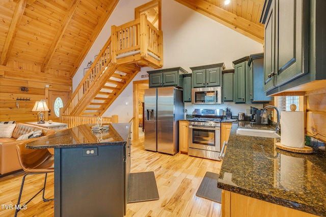 kitchen featuring a sink, appliances with stainless steel finishes, green cabinetry, and high vaulted ceiling