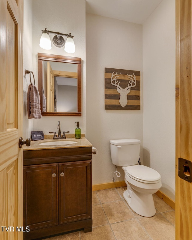 bathroom featuring tile patterned floors, baseboards, vanity, and toilet