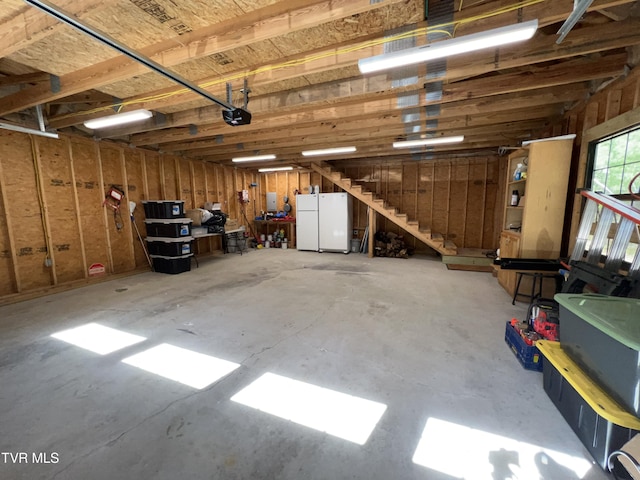 garage featuring freestanding refrigerator and a garage door opener