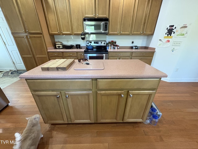 142 Oakwell Ln, Jonesborough, TN 37659 - kitchen featuring appliances with stainless steel finishes, a kitchen island, light countertops, wood-type flooring, and baseboards