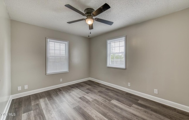 spare room featuring a textured ceiling, a ceiling fan, and dark wood finished floors