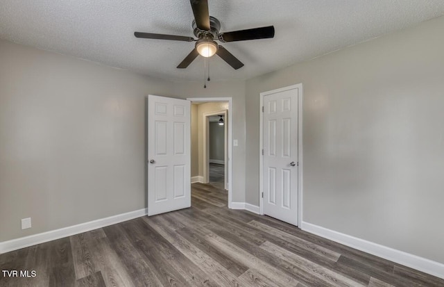 unfurnished bedroom with a textured ceiling, ceiling fan, baseboards, and dark wood finished floors