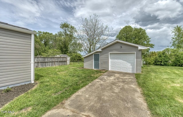 detached garage with fence and concrete driveway