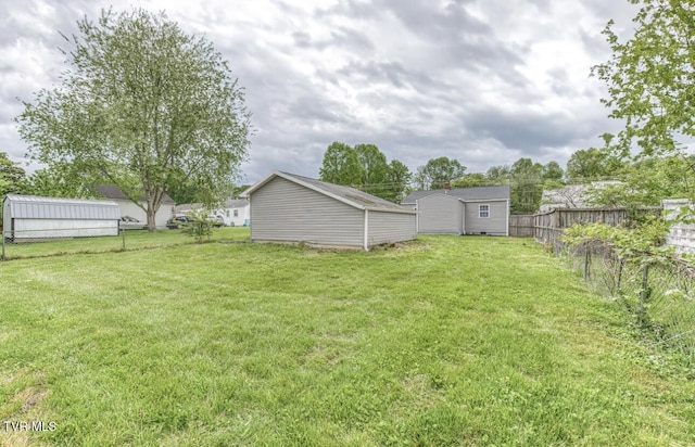 view of yard with an outbuilding, a shed, and a fenced backyard