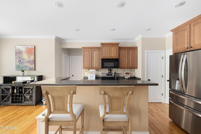 288 Max Jett Rd, Johnson City, TN 37601 - kitchen featuring decorative backsplash, ornamental molding, a breakfast bar area, light wood finished floors, and stainless steel appliances