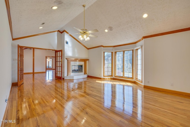 unfurnished living room featuring light wood-style floors, baseboards, a ceiling fan, and a textured ceiling