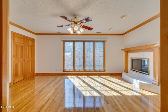 unfurnished living room with a textured ceiling, ceiling fan, light wood-type flooring, and baseboards