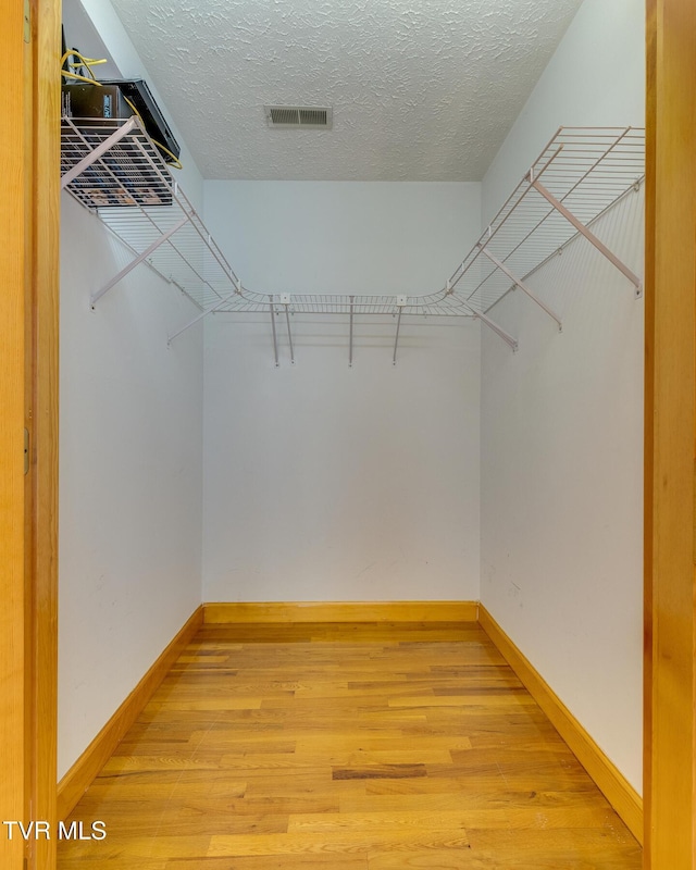 walk in closet featuring light wood finished floors and visible vents
