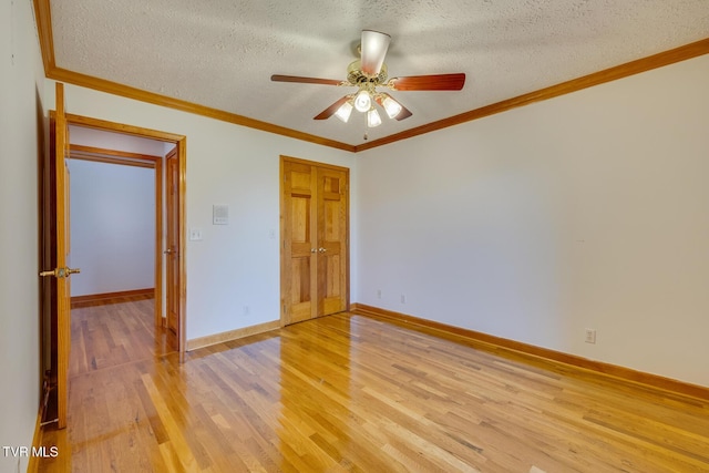 empty room featuring a ceiling fan, baseboards, a textured ceiling, and light wood-type flooring