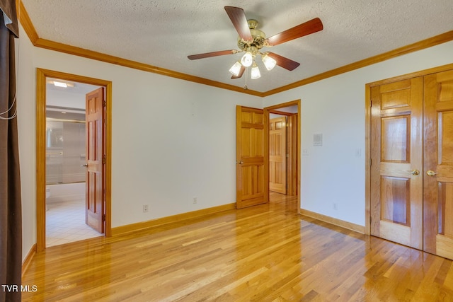 unfurnished bedroom with light wood-type flooring, ornamental molding, a textured ceiling, and a closet