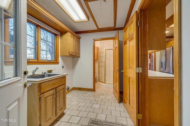 kitchen featuring light tile patterned floors, a sink, light countertops, baseboards, and stainless steel fridge with ice dispenser