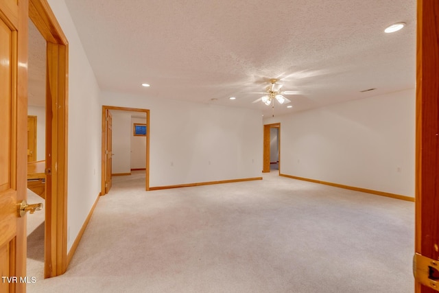 empty room with recessed lighting, light colored carpet, baseboards, a ceiling fan, and a textured ceiling