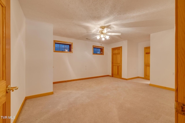 spare room with carpet, a ceiling fan, baseboards, and a textured ceiling