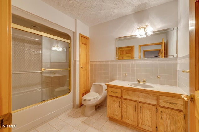 bathroom featuring tile patterned flooring, tile walls, toilet, bath / shower combo with glass door, and a textured ceiling