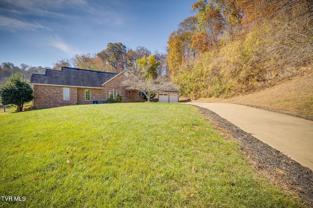 view of front of property featuring a garage, brick siding, a front yard, and driveway