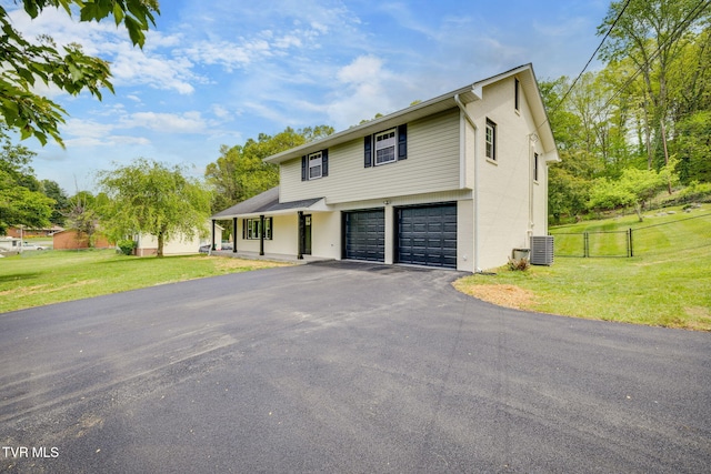 view of front facade with a front lawn, a garage, aphalt driveway, and fence