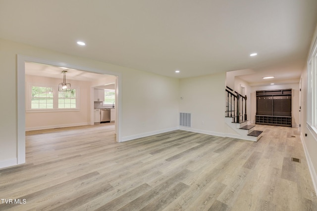 unfurnished living room featuring visible vents, light wood-type flooring, stairway, and recessed lighting