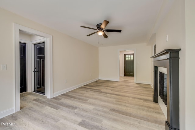 unfurnished living room with baseboards, a ceiling fan, and light wood finished floors