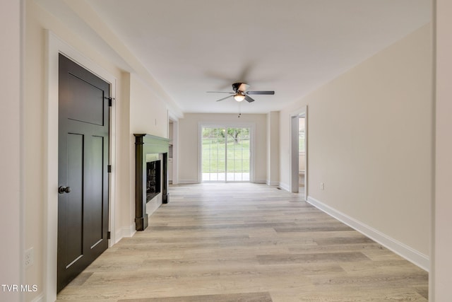hall featuring light wood-style floors and baseboards