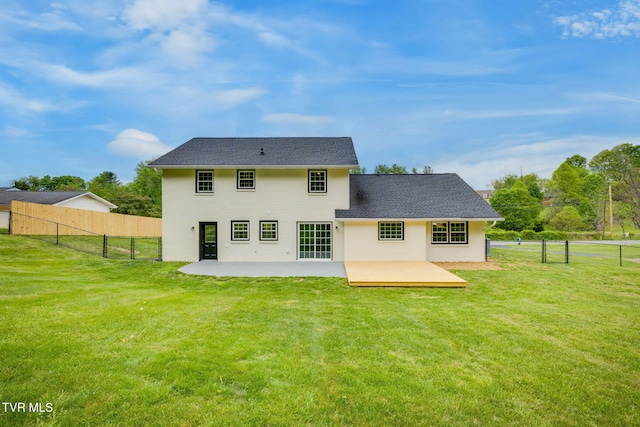 rear view of property featuring a lawn, a wooden deck, and a fenced backyard