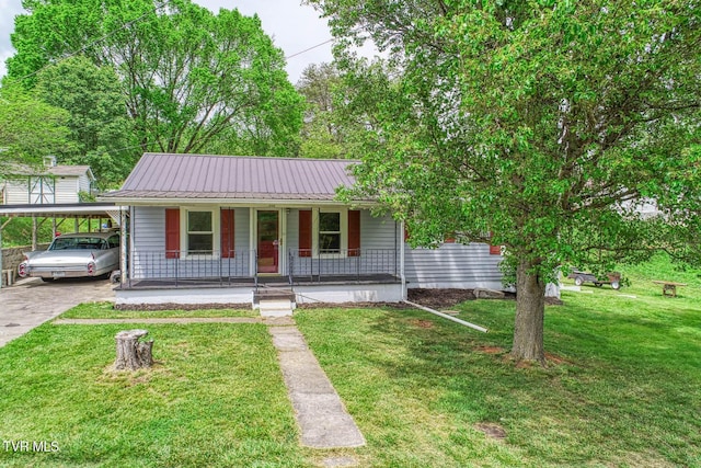 bungalow with a front lawn, covered porch, driveway, and metal roof