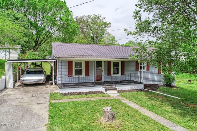 ranch-style house with concrete driveway, covered porch, a front yard, an attached carport, and metal roof