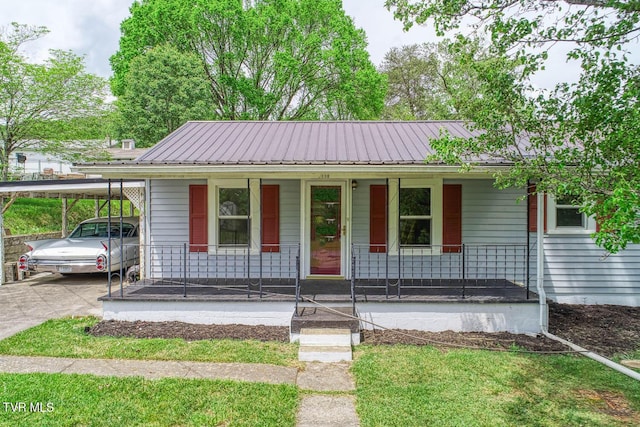 view of front of house with a carport, metal roof, a porch, and driveway