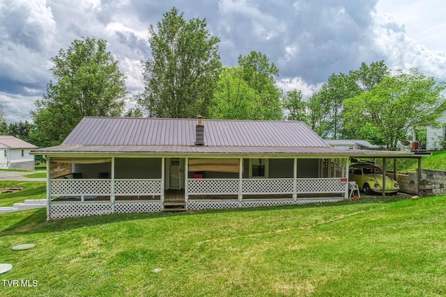 back of property with a yard, metal roof, and an attached carport