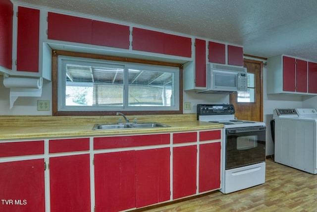 kitchen featuring red cabinetry, washer and clothes dryer, electric range oven, and white microwave