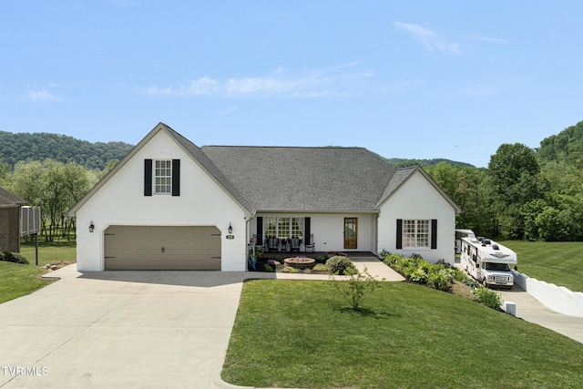view of front of property with concrete driveway, stucco siding, roof with shingles, and a front lawn