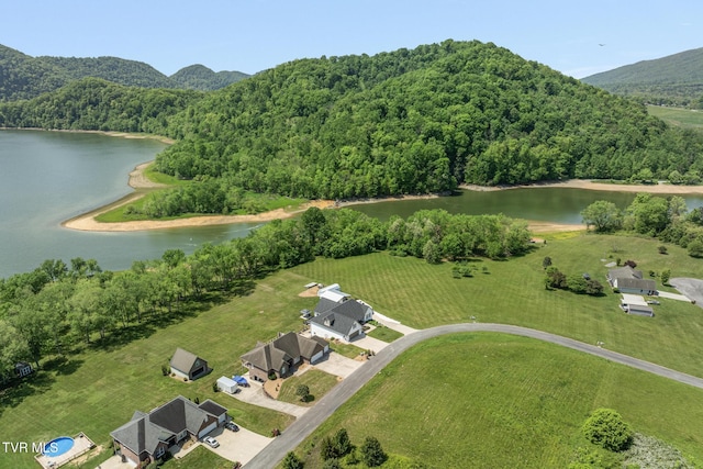 birds eye view of property with a water and mountain view and a wooded view