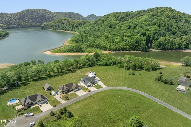 birds eye view of property featuring a water view and a wooded view