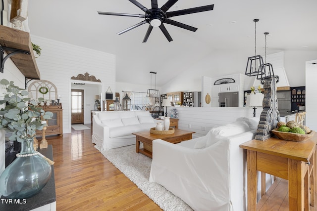 living room with high vaulted ceiling, a ceiling fan, and light wood finished floors