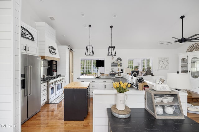 kitchen featuring a kitchen island, open floor plan, high end appliances, and butcher block counters