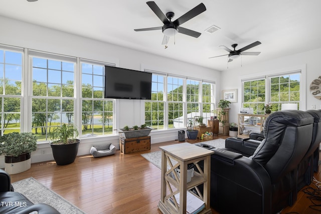 living room featuring ceiling fan, visible vents, and a healthy amount of sunlight