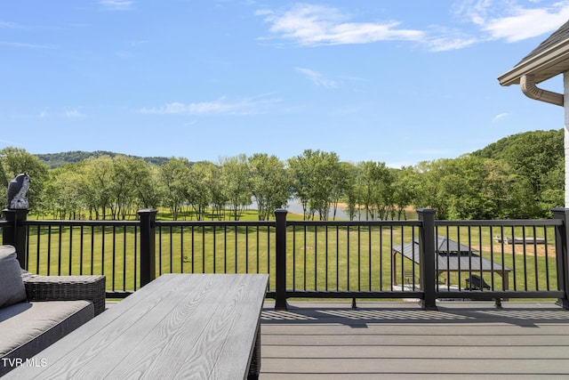 wooden terrace with a lawn and a water view