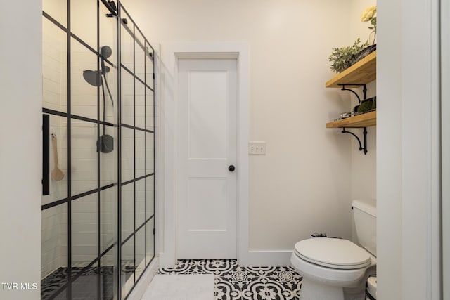 full bathroom featuring toilet, tile patterned floors, a shower stall, and baseboards